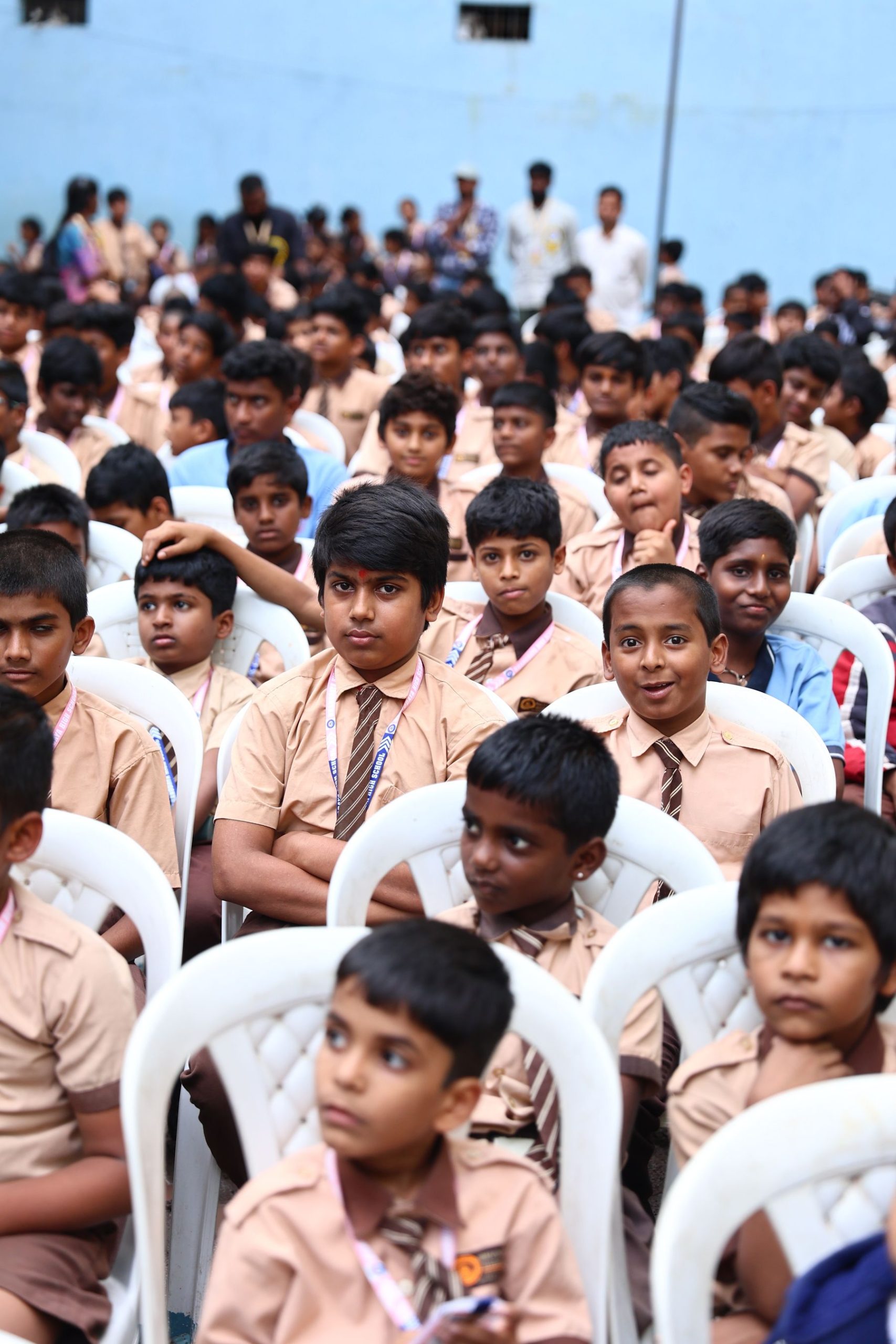 School assembly seated in rows in a courtyard