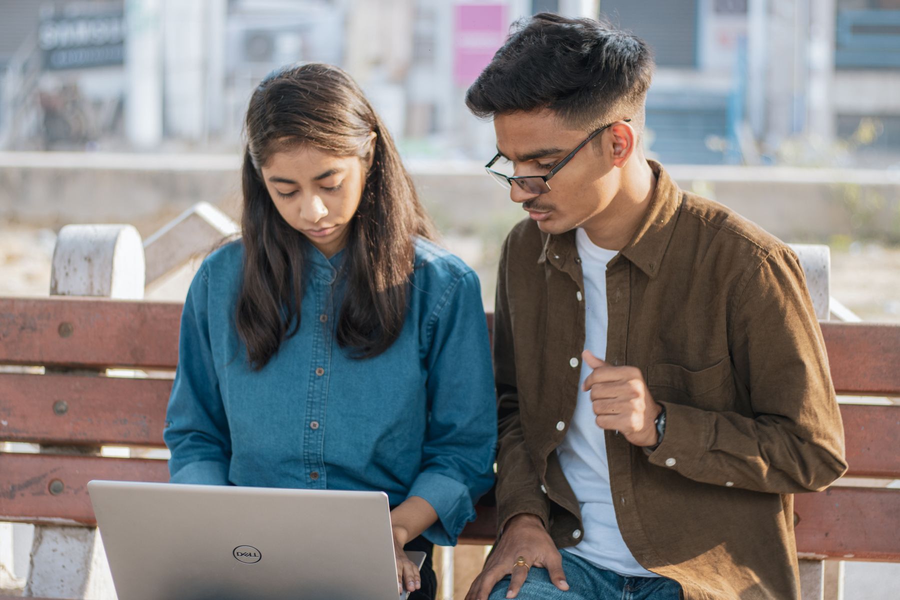 Young people working on a laptop outdoors