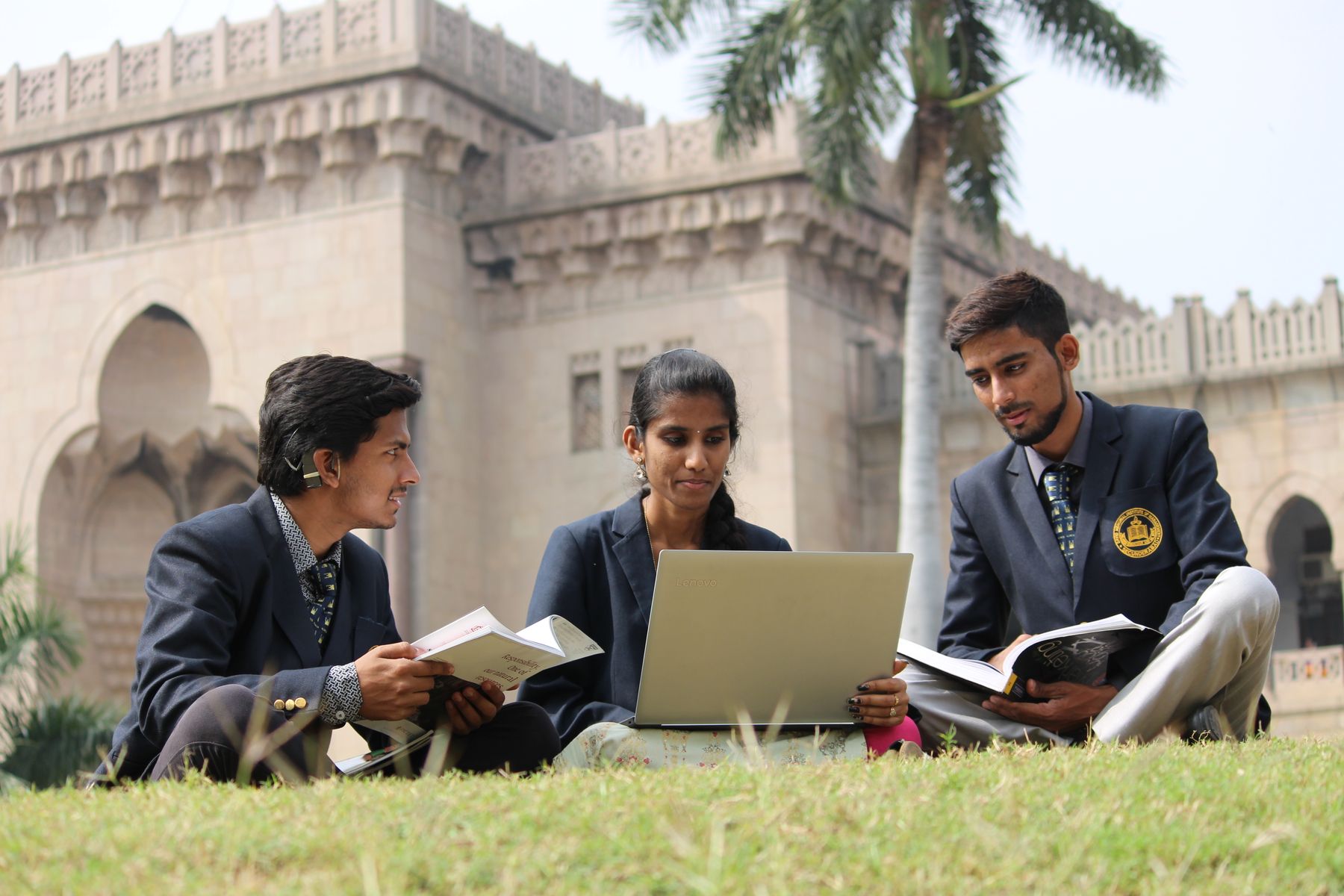 Students studying outdoors on a campus lawn
